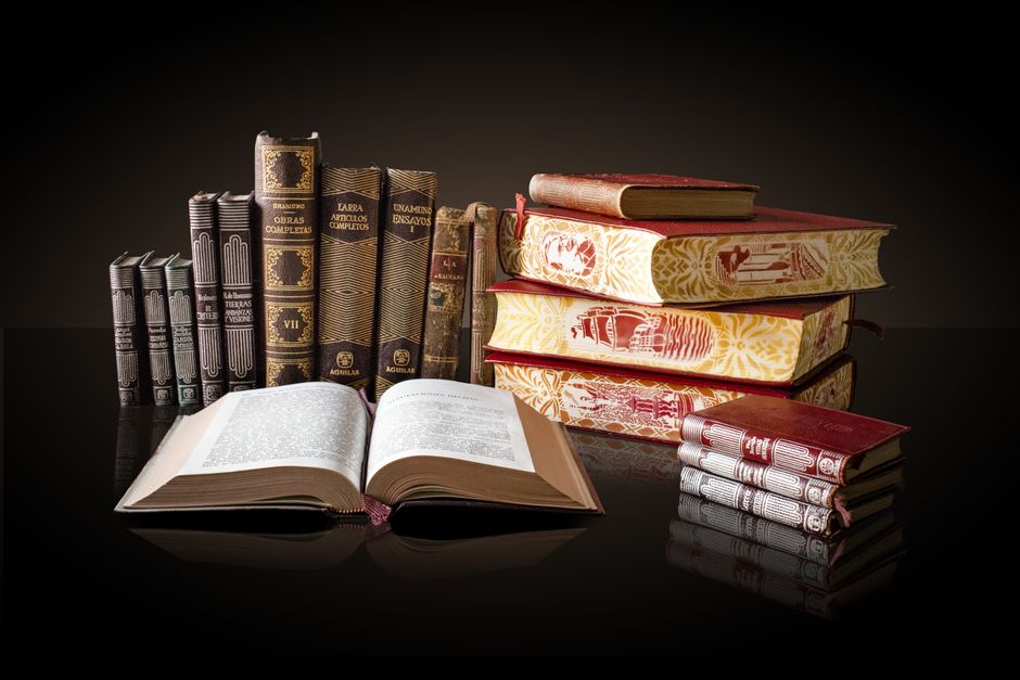 Bookshelf with various books in a well-lit home office, warm ambiance.