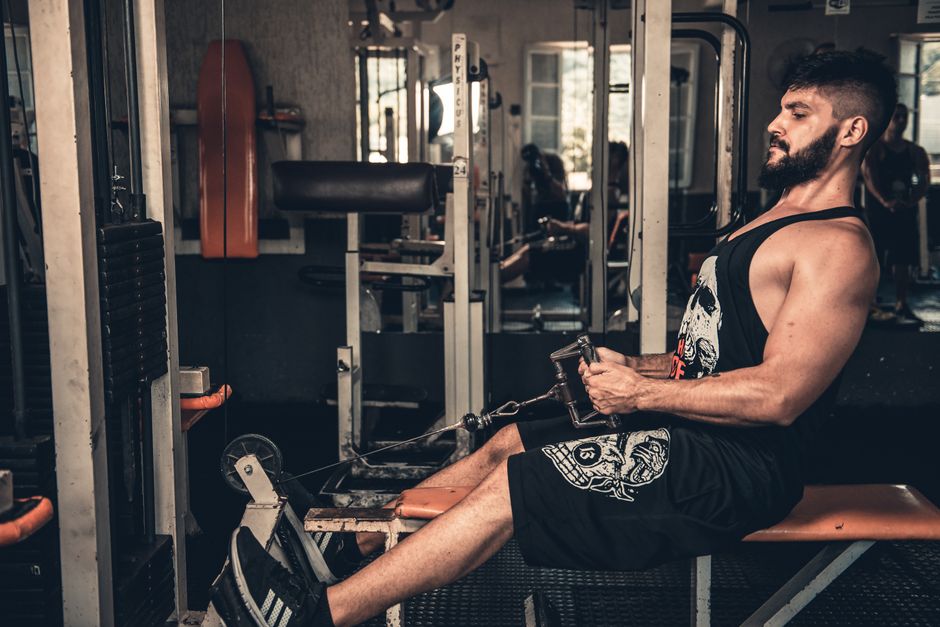 Athletes resting on a gym floor beside heavy barbells after an intense weightlifting session.