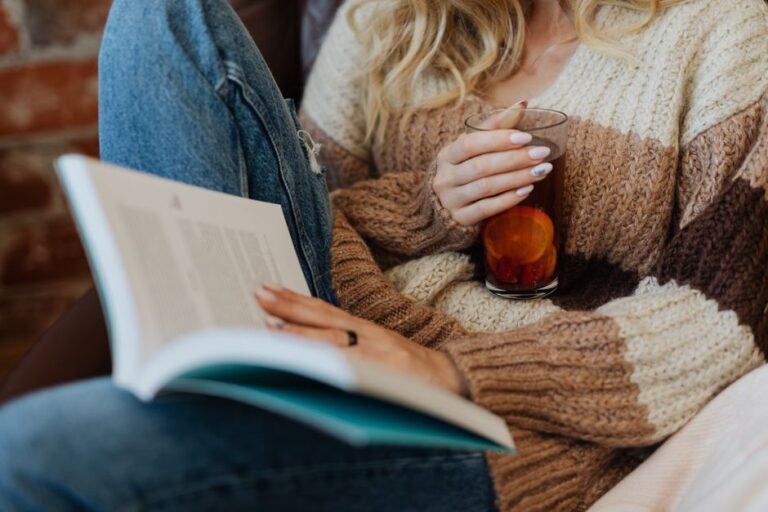Woman relaxing with a book and a warm drink. Cozy indoor setting for tranquility and leisure.