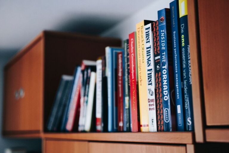 A variety of books neatly arranged on a wooden bookshelf.